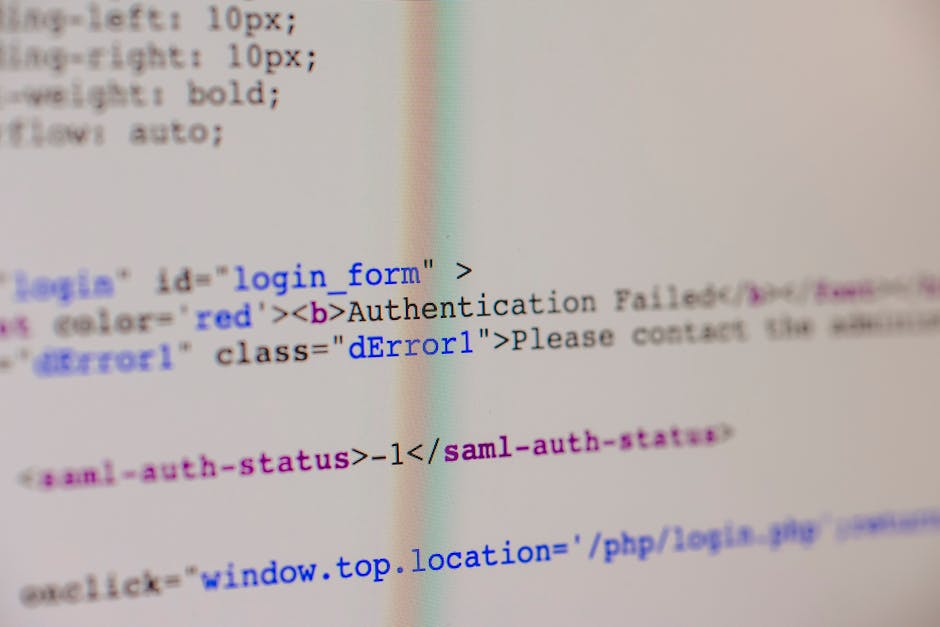 A close-up view of a person's hands typing on a MacBook laptop with a black keyboard, displaying a code editor with lines of programming code in various colors on the screen. The device is placed on a
